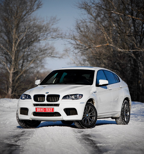 Тест-драйв BMW X6 M::Внешне от гражданской версии BMW X6 xDrive50i, послужившей основой для X6 M, наш герой отличается агрессивным обвесом с «дышащим» передним бампером, 20-дюймовыми M-дисками, фамильным квартетом выхлопных патрубков и профилем, более приземлённым из-за заниженной на десять миллиметров подвески. Тест-драйв BMW X6 M
